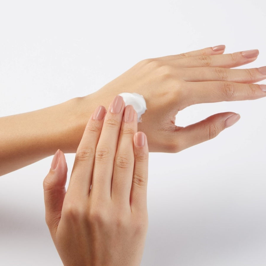 A model applying and smoothing in shea butter hand cream 